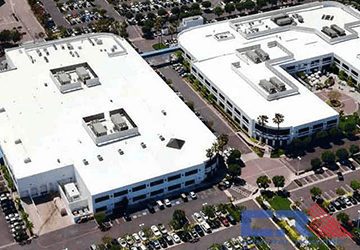 ingramMicro Arial view of two white industrial building with white roof with skylights and Air Conditioning units